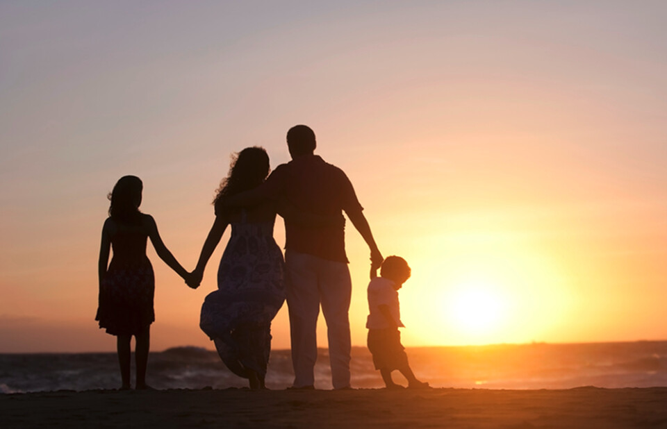 Family silhouette at sunset with ocean view